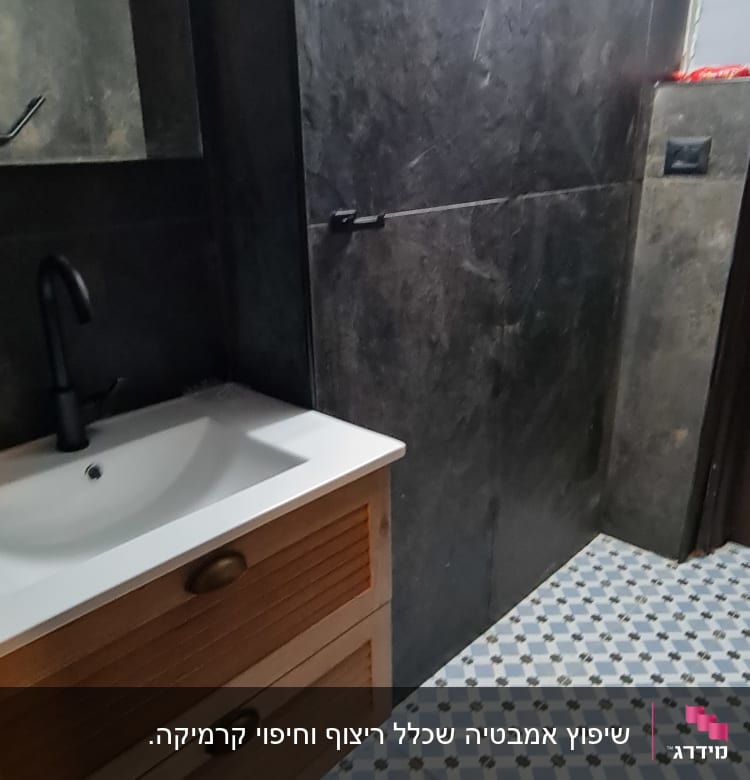 חדר אמבטיה עם כיור, ארון עץ ורצפת אריחים מעוצבת